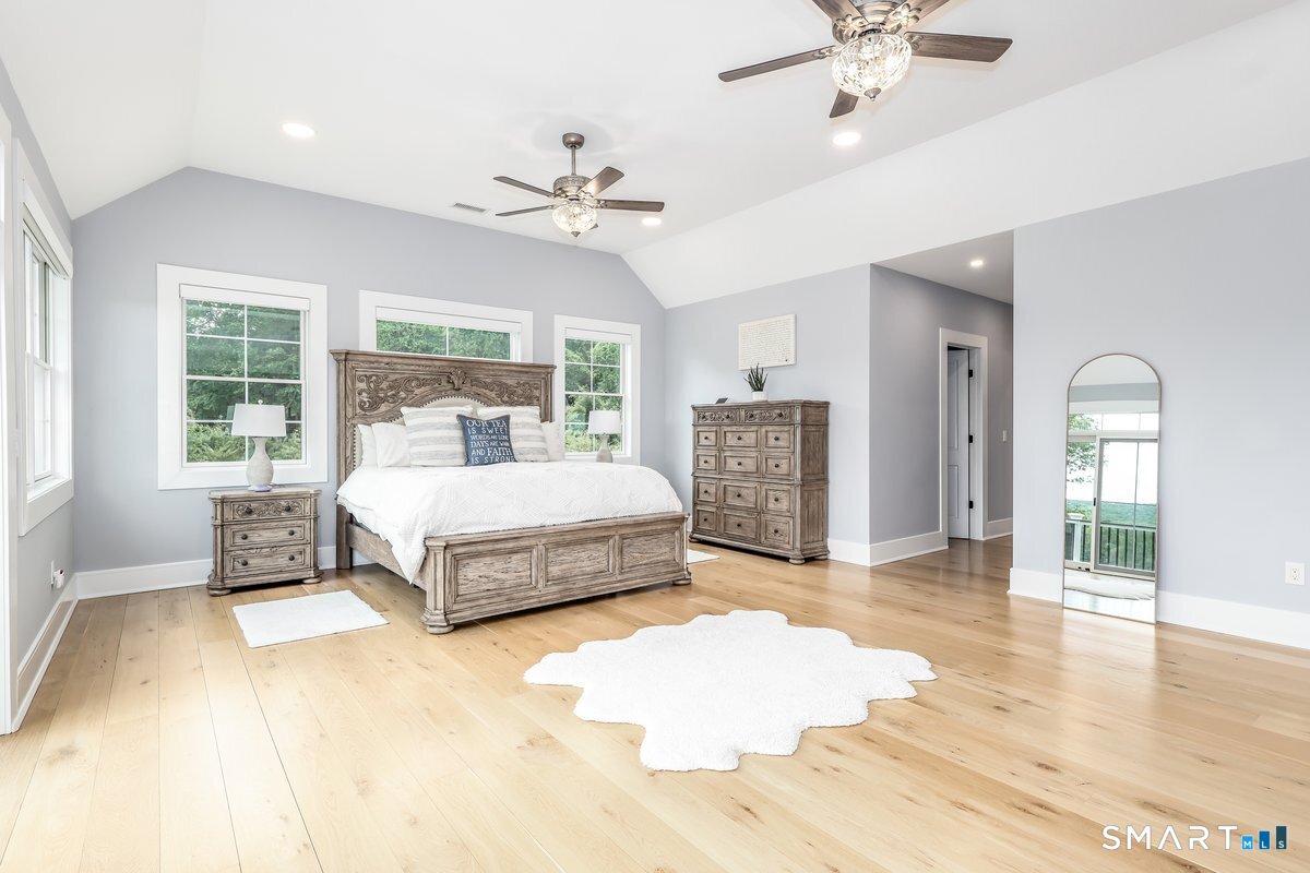 2 Pond View Lane Sherman, CT 06784 - Photo 20 of 40 a spacious bedroom with a large bed and a chandelier