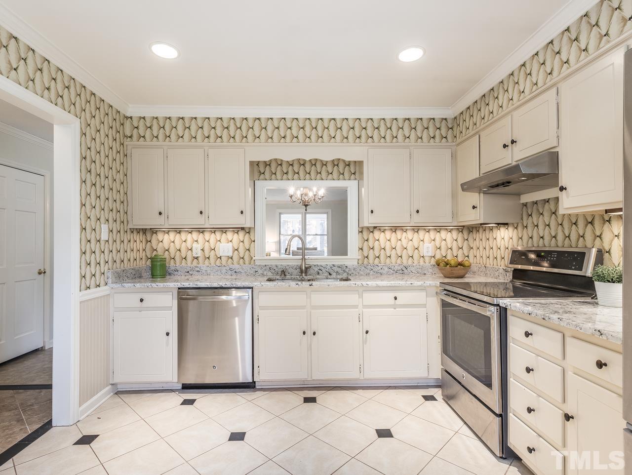 1507 Edgeside Court Raleigh, NC 27609 - Photo 8 of 28 a kitchen with granite countertop white cabinets white appliances with a sink and dishwasher
