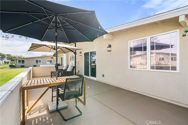 a view of a patio with a table and chairs under an umbrella