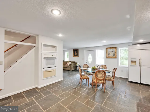 a kitchen with stainless steel appliances kitchen island granite countertop a sink and a refrigerator