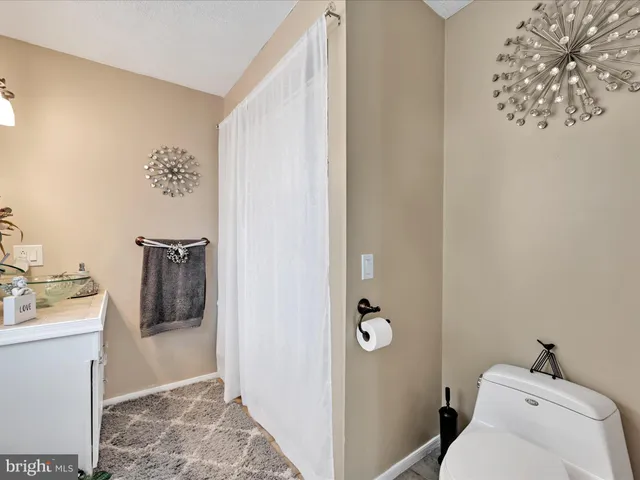 a bedroom with a large bed a chandelier and dresser