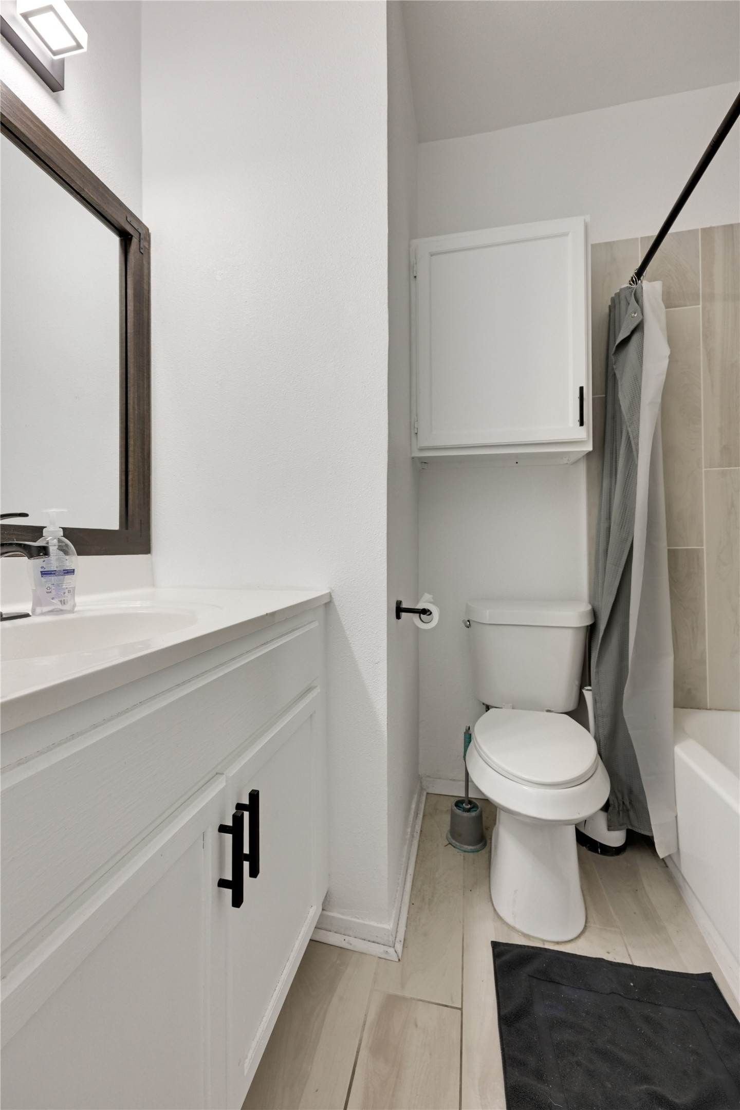 2801 Rio Grande Street, Unit 103 Austin, TX 78705 - Photo 9 of 15 a bathroom with a sink a toilet and a mirror