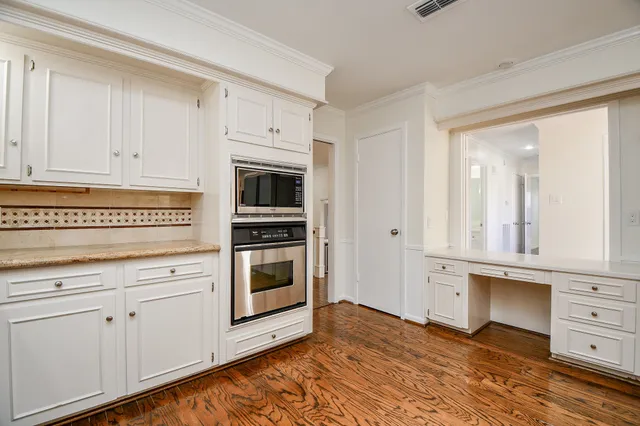 a kitchen with granite countertop white cabinets and stainless steel appliances
