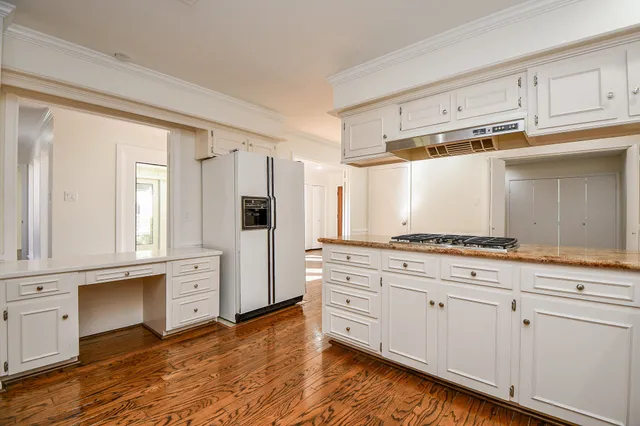 a kitchen with stainless steel appliances white cabinets and a refrigerator