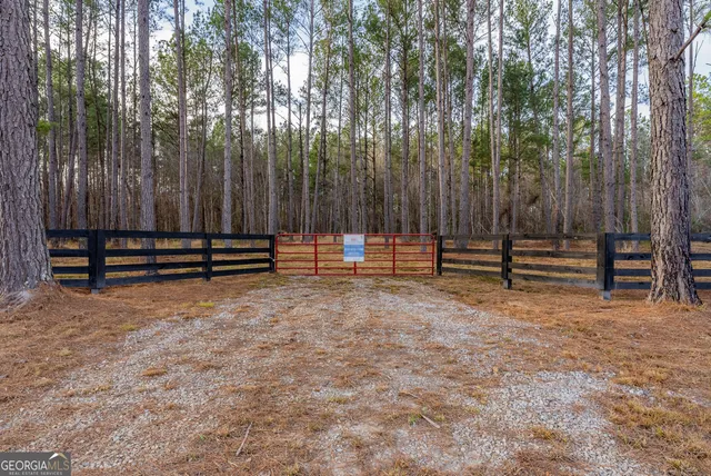 a view of outdoor space with wooden fence and trees