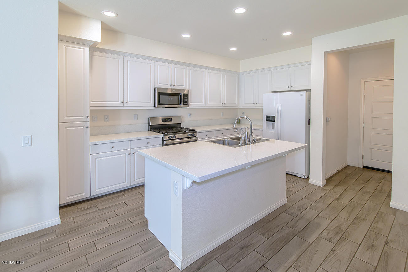 2464 Blossom Ridge Court, Unit 2 Simi Valley, CA 93063 - Photo 12 of 41 a kitchen with a sink a stove a refrigerator and white cabinets