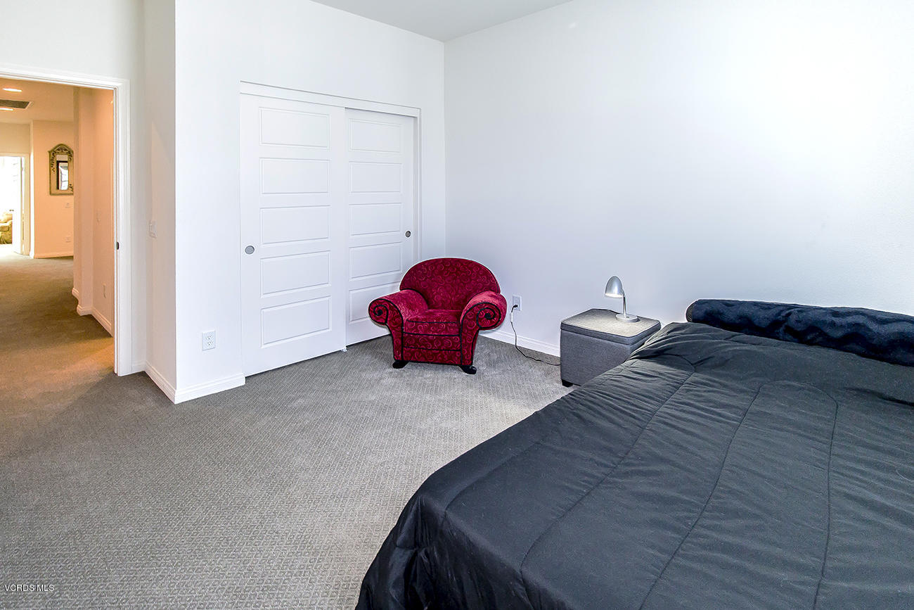 2464 Blossom Ridge Court, Unit 2 Simi Valley, CA 93063 - Photo 25 of 41 a bedroom with a bed and a chandelier