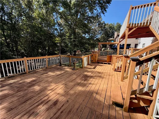 a view of a patio with table and chairs a barbeque with wooden floor and fence