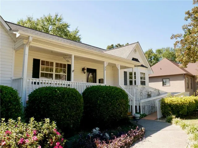 a view of a house with wooden fence next to a yard