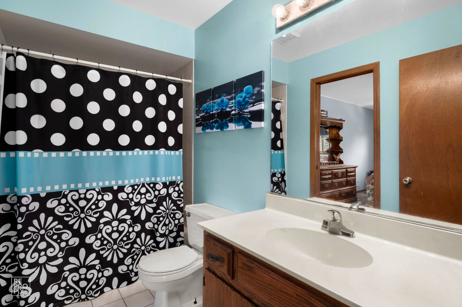 3235 192nd Street Lansing, IL 60438 - Photo 9 of 28 a bathroom with a sink a toilet a mirror and shower curtain