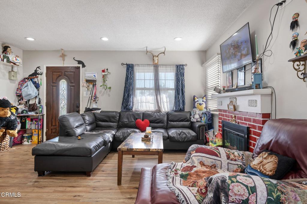 145 Homer Street Oxnard, CA 93033 - Photo 5 of 15 a living room with furniture a fireplace and a flat screen tv