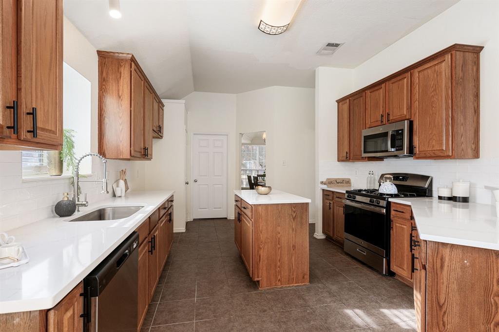 10210 Bent Tree Drive Rowlett, TX 75089 - Photo 5 of 27 a kitchen with stainless steel appliances granite countertop a sink stove and refrigerator