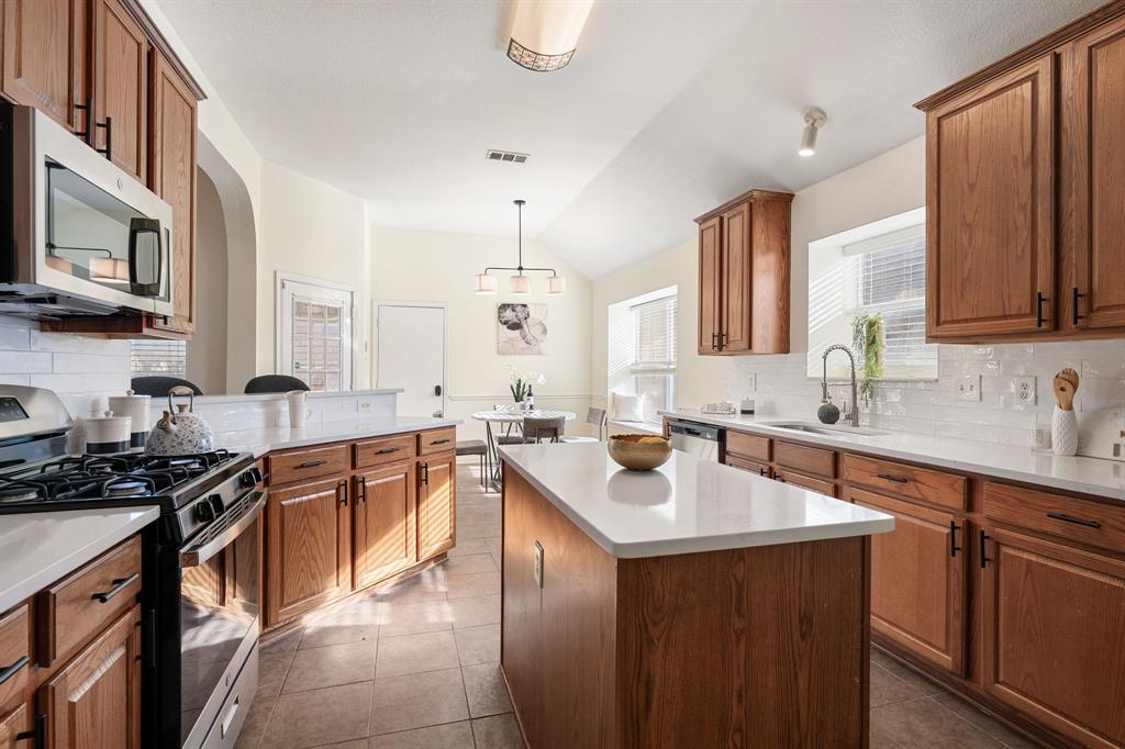 10210 Bent Tree Drive Rowlett, TX 75089 - Photo 9 of 27 a kitchen with a sink stove top oven and cabinets