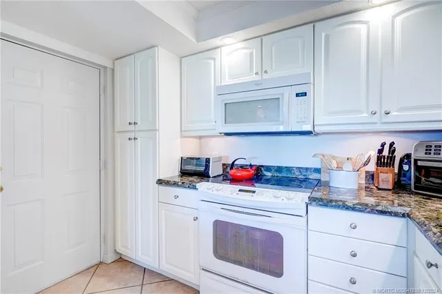 a kitchen with granite countertop white cabinets and sink