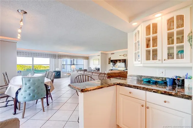 a kitchen with stainless steel appliances granite countertop a sink a stove and a dining table view
