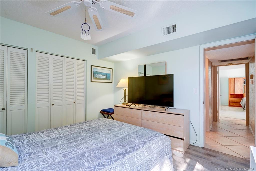 1289 Northeast Ocean Boulevard, Unit 2 Stuart, FL 34996 - Photo 20 of 41 a bedroom with a bed and a flat screen tv