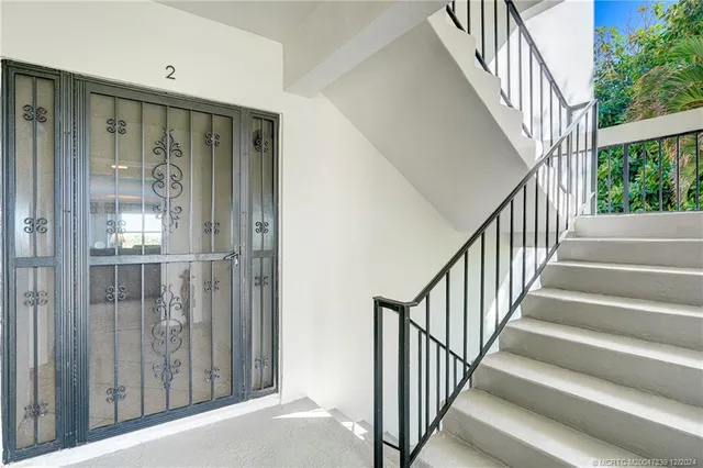 a view of staircase with railing and white walls