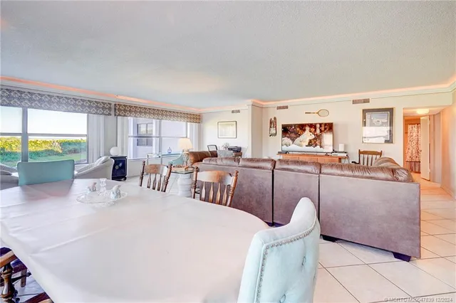 a living room with furniture a large window and a table