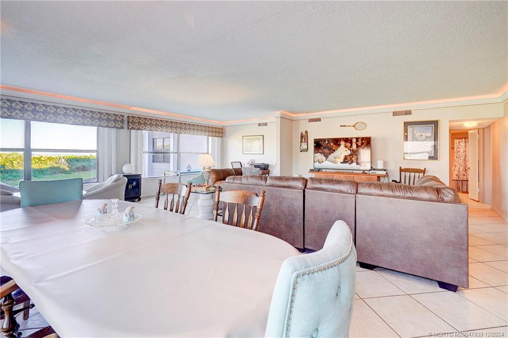 1289 Northeast Ocean Boulevard, Unit 2 Stuart, FL 34996 - Photo 9 of 41 a living room with furniture a large window and a table