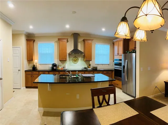 a large kitchen with stainless steel appliances granite countertop a sink a stove and a refrigerator