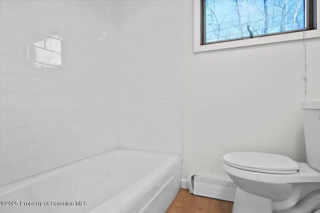 a bathroom with a toilet and bathtub