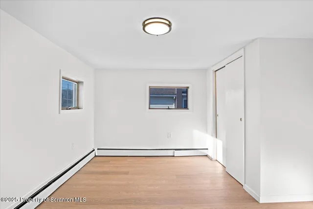 a view of a room with wooden floor and window