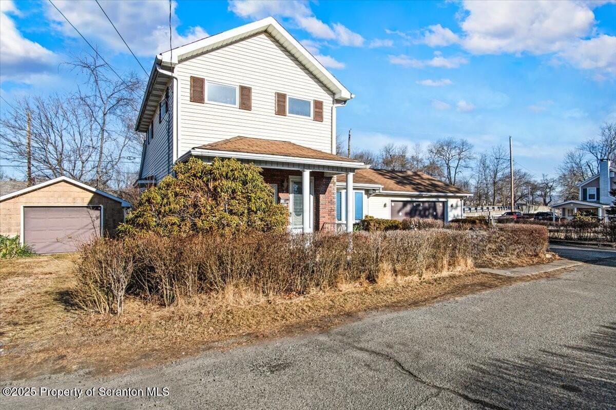 134 Lampman Street Avoca, PA 18641 - Photo 28 of 34 a view of a white house with a yard next to a road