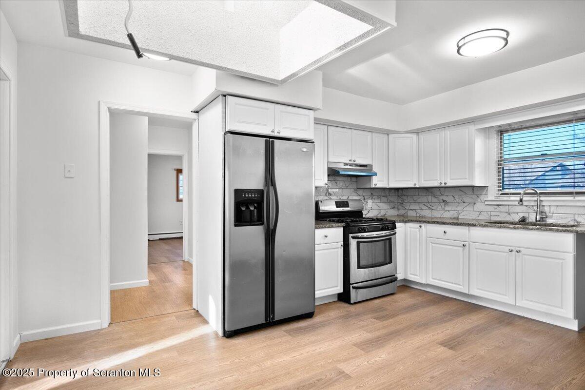 134 Lampman Street Avoca, PA 18641 - Photo 6 of 34 a kitchen with stainless steel appliances granite countertop a refrigerator a sink and white cabinets
