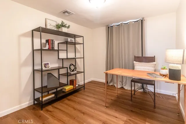 a living room with furniture a wooden floor and next to a window