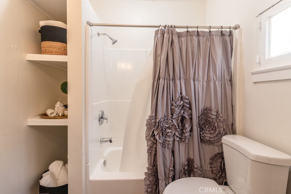 503 Palm Way Needles, CA 92363 - Photo 39 of 50 a bathroom with a toilet and a shower curtain