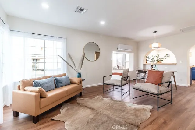 a living room with furniture chandelier and a large window
