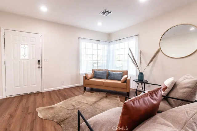 a living room with furniture a wooden floor and a window