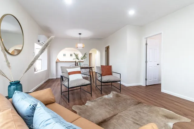 a living room with furniture a mirror and a painting on the wall