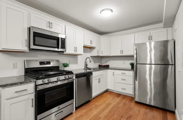 a kitchen with white cabinets and stainless steel appliances