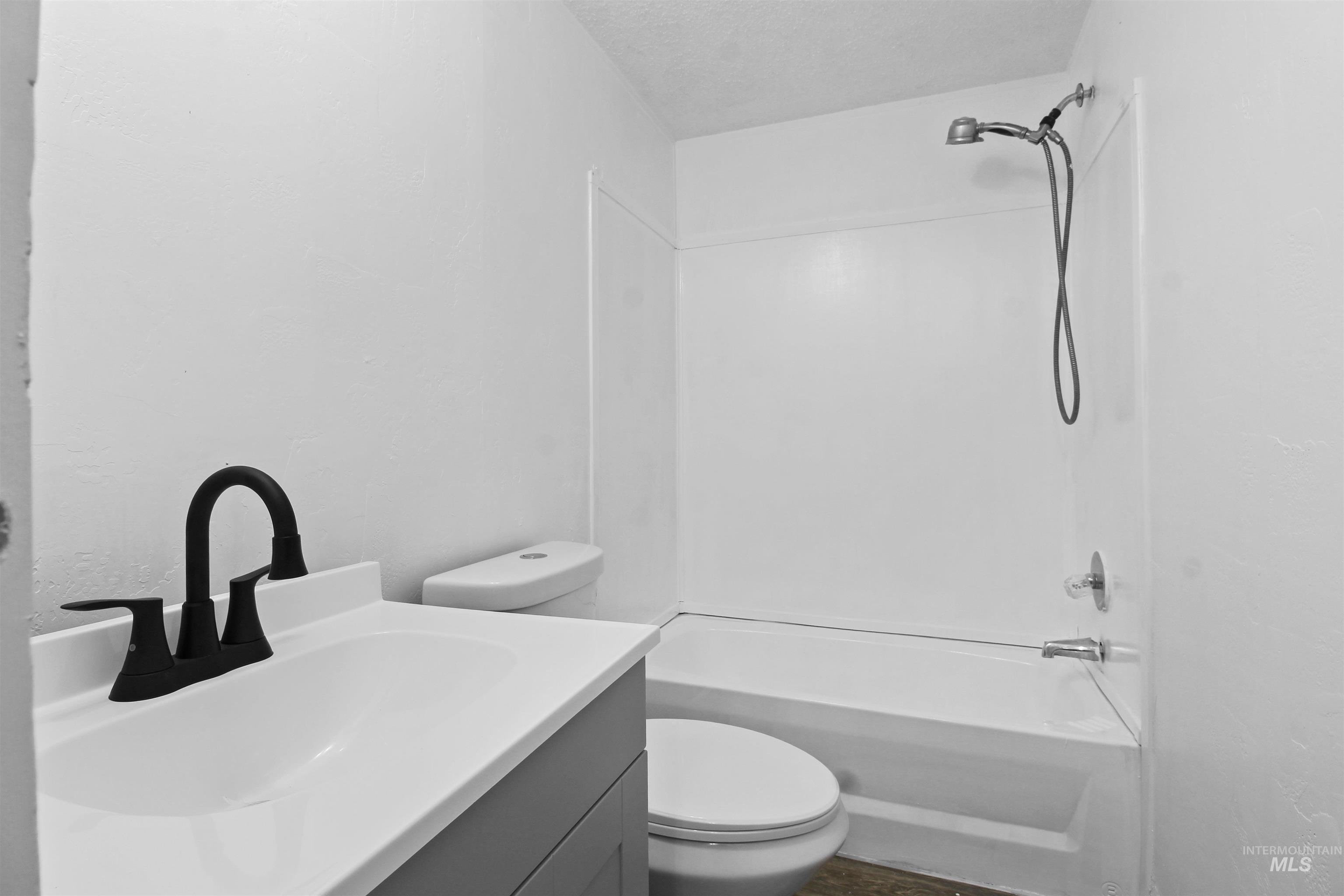 377 South 200 West, Unit 36 Rupert, ID 83350 - Photo 17 of 31 Bathroom featuring tub / shower combination, vanity, and a textured ceiling