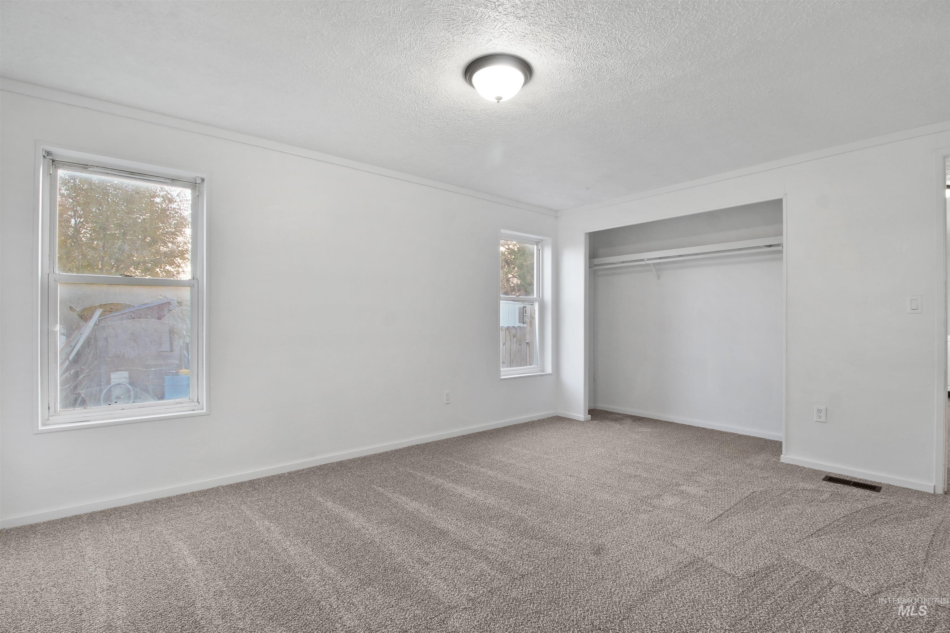 377 South 200 West, Unit 36 Rupert, ID 83350 - Photo 21 of 31 Unfurnished bedroom with carpet floors, a closet, a textured ceiling, and ornamental molding
