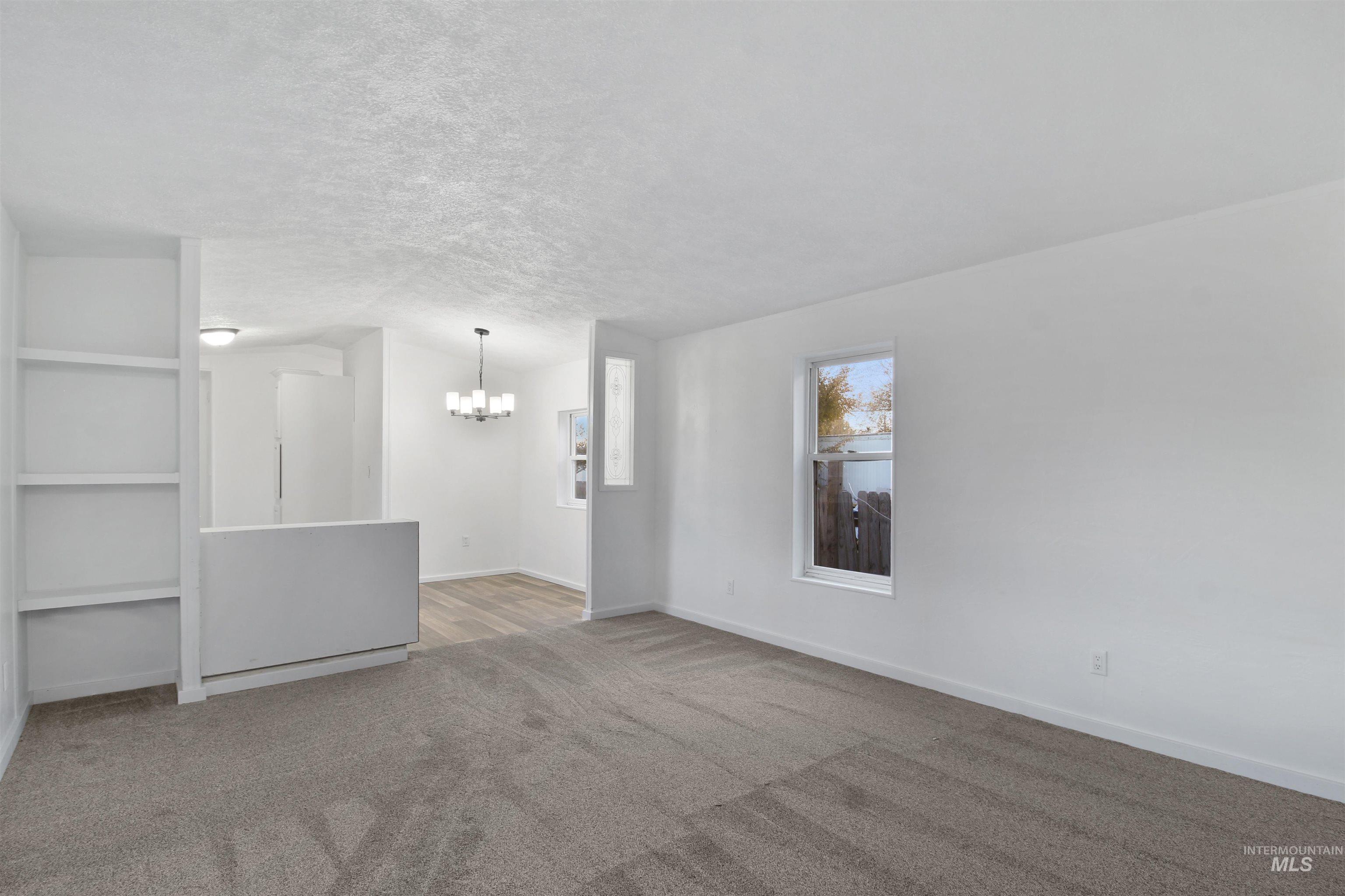 377 South 200 West, Unit 36 Rupert, ID 83350 - Photo 26 of 31 Carpeted empty room featuring a textured ceiling and a chandelier