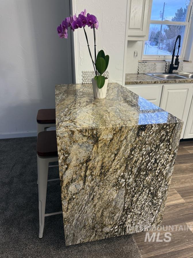 377 South 200 West, Unit 36 Rupert, ID 83350 - Photo 8 of 31 Kitchen view of dark stone countertops, white cabinetry, and a breakfast bar