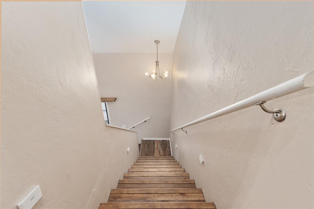 7200 Southwest 8th Avenue, Unit E29 Gainesville, FL 32607 - Photo 31 of 47 a view of a hallway with wooden floor and staircase