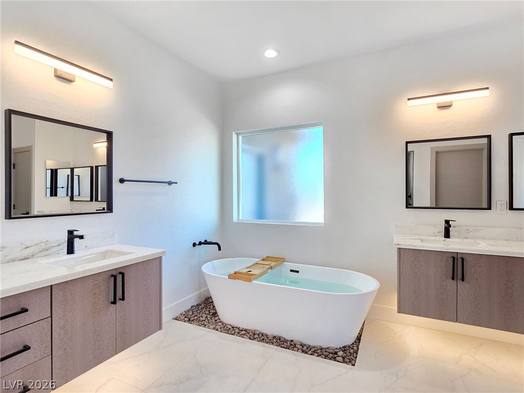 1120 West Gamebird Road Pahrump, NV 89048 - Photo 31 of 36 Bathroom featuring two vanities, a soaking tub, light marble finish flooring, and recessed lighting