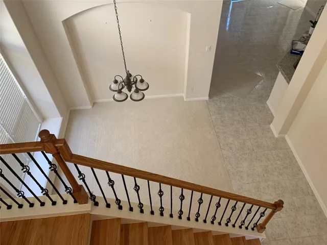 a view of staircase with railing and white walls