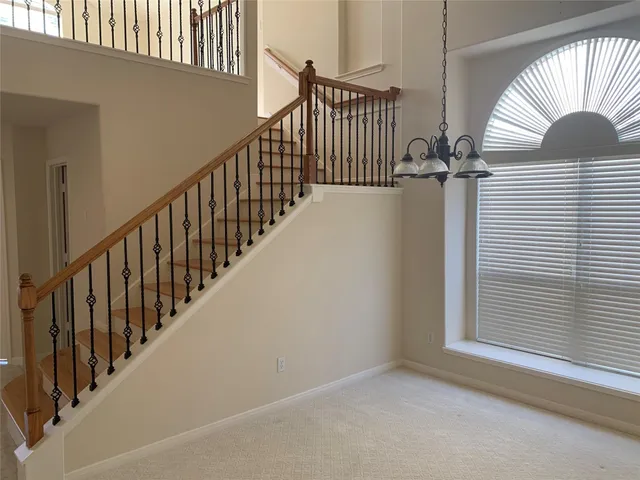 a view of staircase with railing and a window