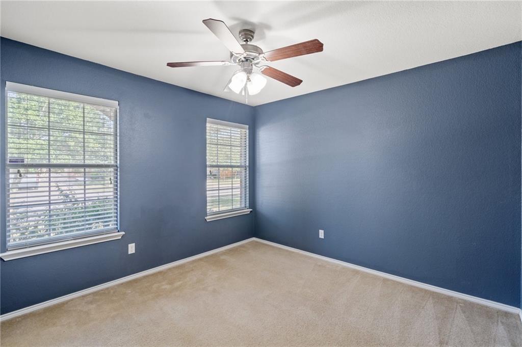 20224 Merlin Falcon Trail Pflugerville, TX 78660 - Photo 33 of 40 A well-lit bedroom offering a cozy atmosphere with ceiling fan comfort.