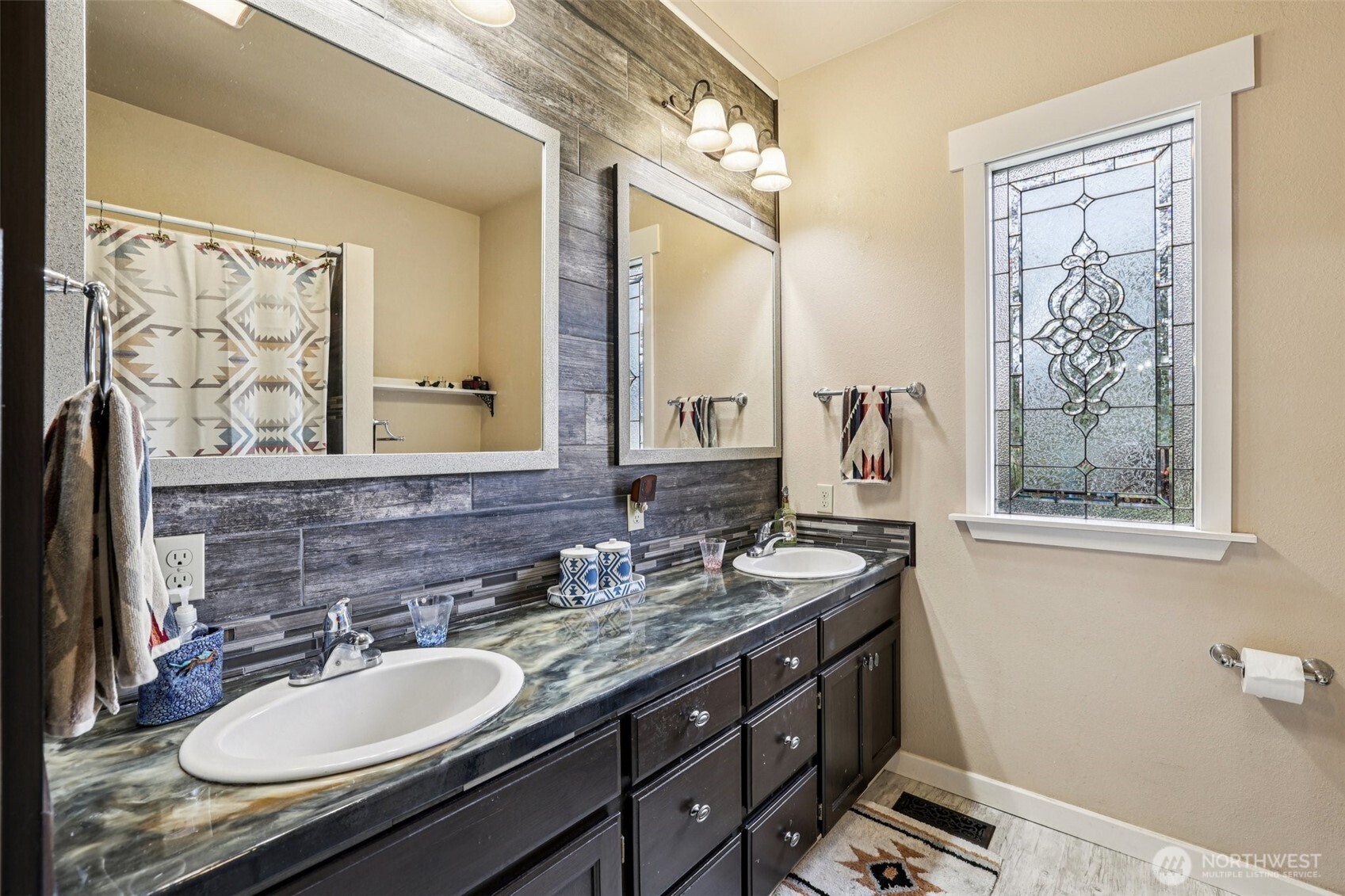 537 McNaught Road South Roy, WA 98580 - Photo 14 of 32 a bathroom with double vanity sinks a mirror and a shower