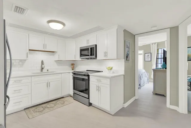 a kitchen with white cabinets and stainless steel appliances