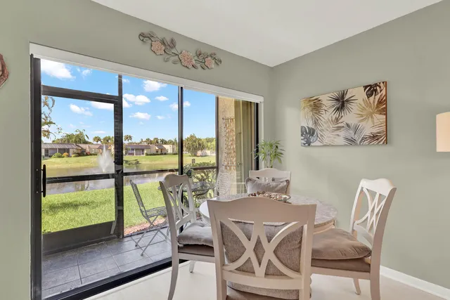 a dining room with furniture water view and a floor to ceiling window