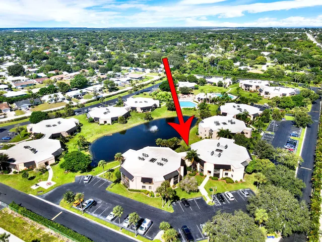 an aerial view of a house with a garden and lake view