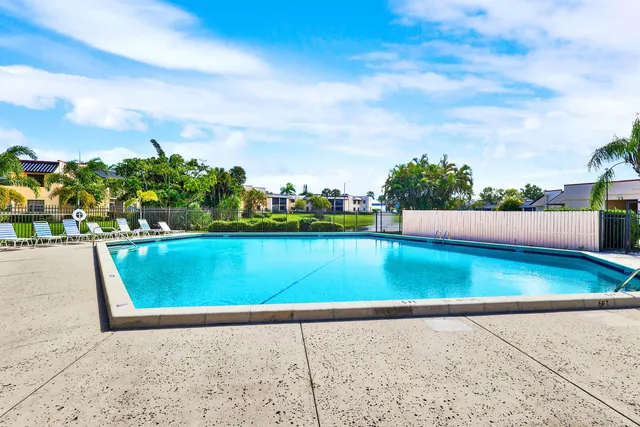 a room with wooden floor pool table and windows