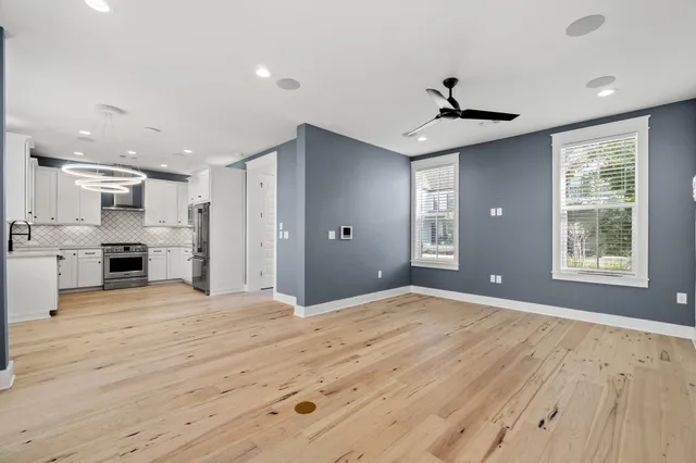 a large kitchen with stainless steel appliances kitchen island granite countertop a refrigerator oven a stove and a sink with wooden floor