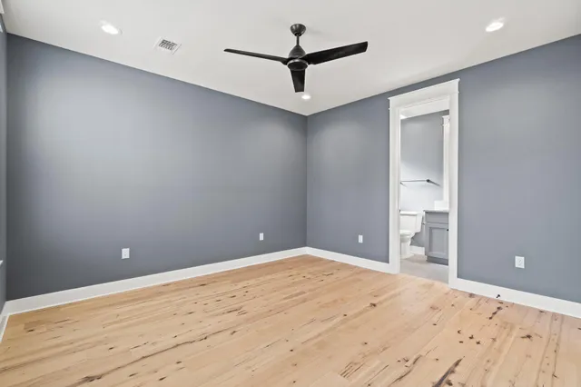 a view of a big room with wooden floor and a ceiling fan